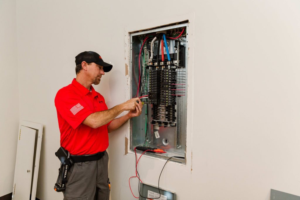 An electrician performing an electrical panel installation