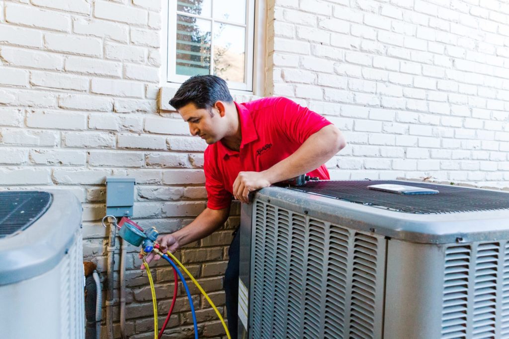 A HVAC professional fixing a malfunctioning heat pump